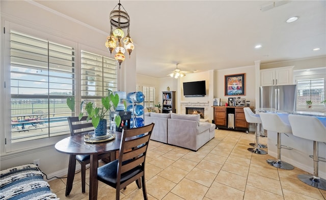 tiled dining room with crown molding and ceiling fan