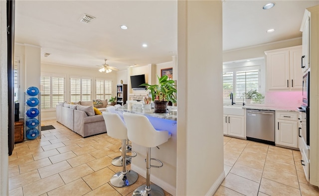 kitchen featuring a wealth of natural light, light stone countertops, white cabinets, and appliances with stainless steel finishes