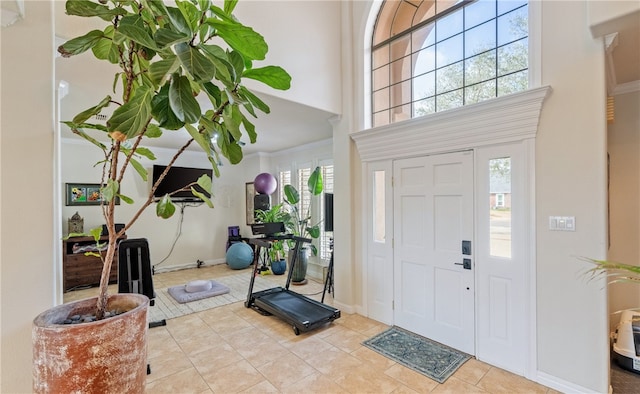 entryway featuring light tile patterned floors, a towering ceiling, and a wealth of natural light