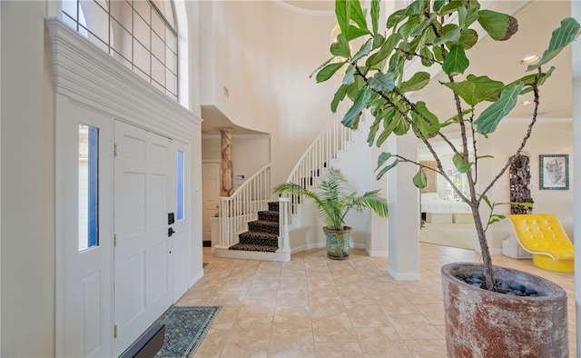 tiled foyer entrance featuring ornate columns and a towering ceiling