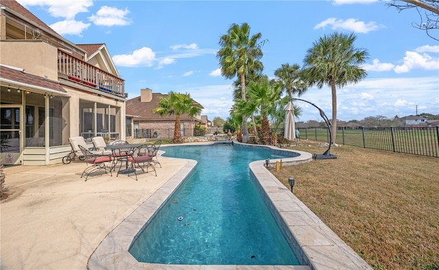 view of pool with a yard, a patio area, and a sunroom