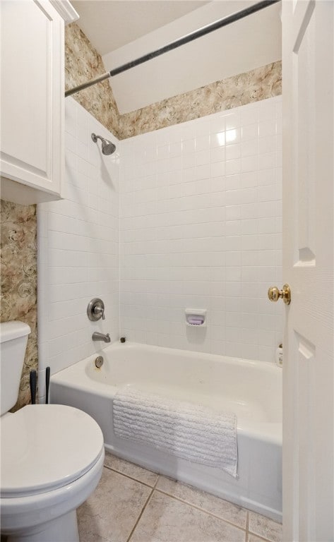 bathroom featuring tiled shower / bath combo, tile patterned floors, and toilet