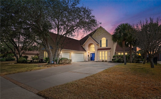 view of front facade featuring a garage and a lawn