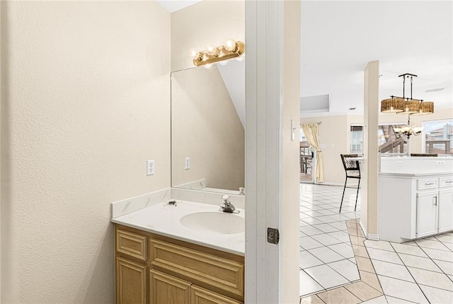 bathroom featuring vanity, an inviting chandelier, and tile patterned floors