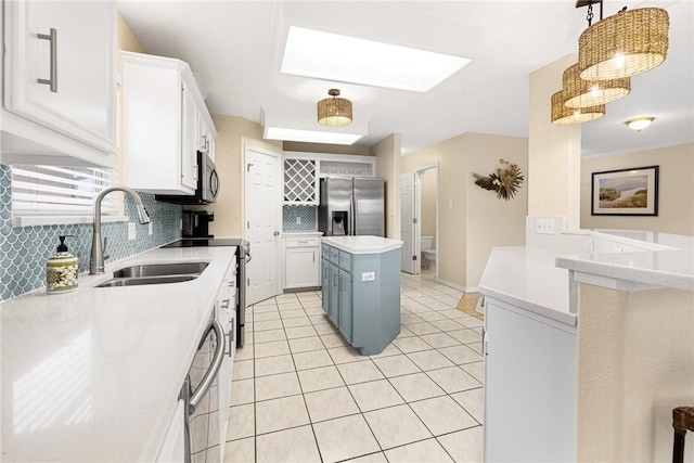 kitchen with backsplash, appliances with stainless steel finishes, light countertops, and a sink