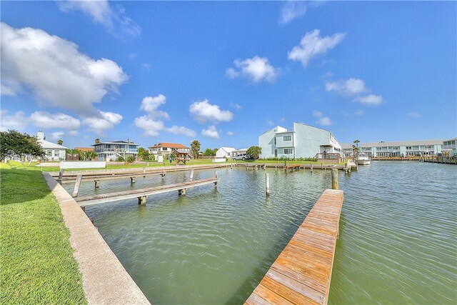 dock area with a lawn and a water view