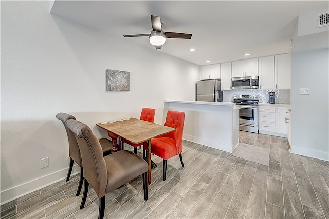 dining area with ceiling fan and light hardwood / wood-style flooring