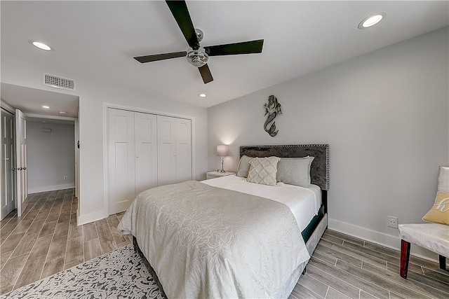 bedroom featuring hardwood / wood-style flooring, ceiling fan, and a closet