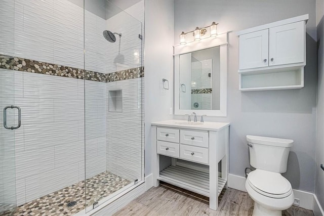 full bathroom with a stall shower, baseboards, toilet, and wood finished floors