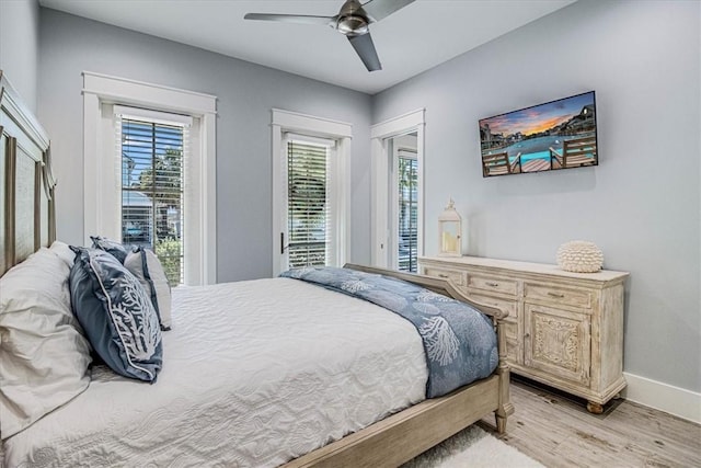 bedroom featuring access to outside, multiple windows, light wood-type flooring, and baseboards