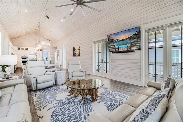 living area featuring high vaulted ceiling, wooden walls, ceiling fan with notable chandelier, wood finished floors, and wood ceiling