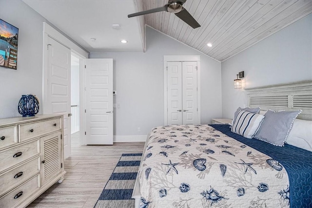 bedroom featuring light wood finished floors, a closet, wood ceiling, vaulted ceiling, and baseboards