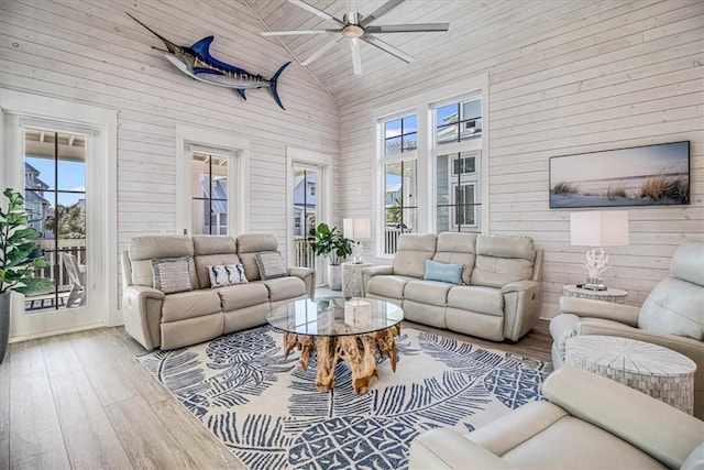 living area featuring high vaulted ceiling, a healthy amount of sunlight, and wood finished floors