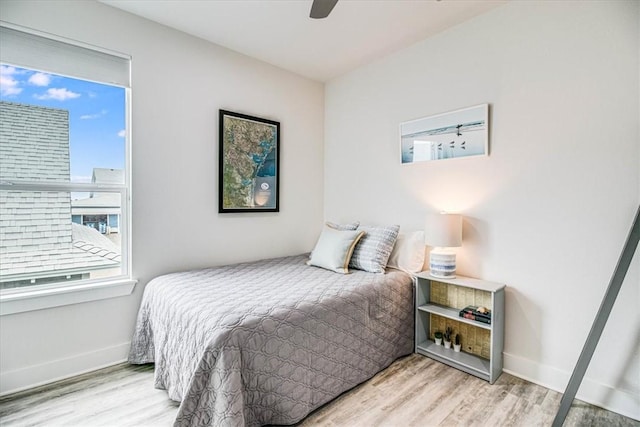 bedroom featuring a ceiling fan, wood finished floors, and baseboards