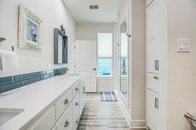 full bathroom featuring visible vents, baseboards, a stall shower, wood finished floors, and vanity