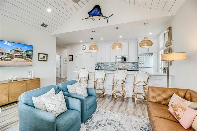 living room featuring light wood-type flooring, visible vents, lofted ceiling, and wood ceiling