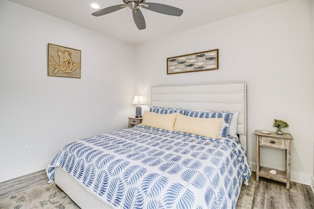 bedroom with ceiling fan, baseboards, and wood finished floors