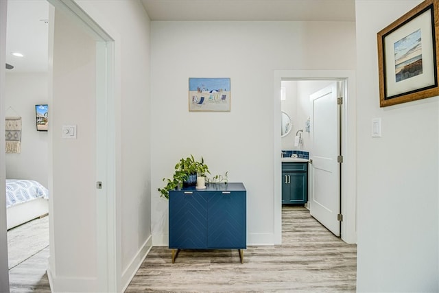 corridor with baseboards and light wood-type flooring