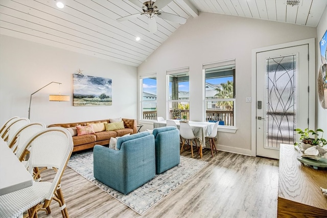 living area featuring wood finished floors, baseboards, lofted ceiling with beams, recessed lighting, and ceiling fan