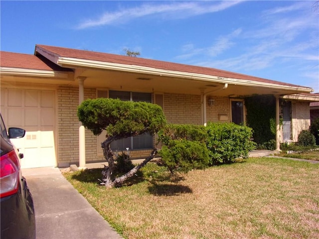 view of front of house with an attached garage, brick siding, and a front yard