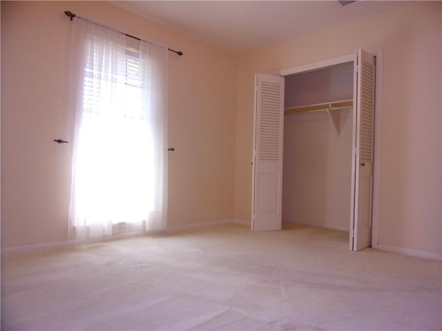 unfurnished bedroom featuring a closet, carpet, and baseboards