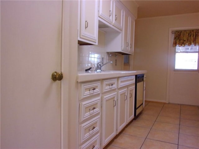 kitchen featuring light tile patterned floors, light countertops, decorative backsplash, a sink, and dishwasher