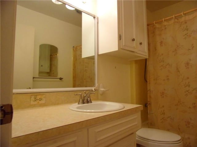 full bath with a shower with shower curtain, vanity, and toilet