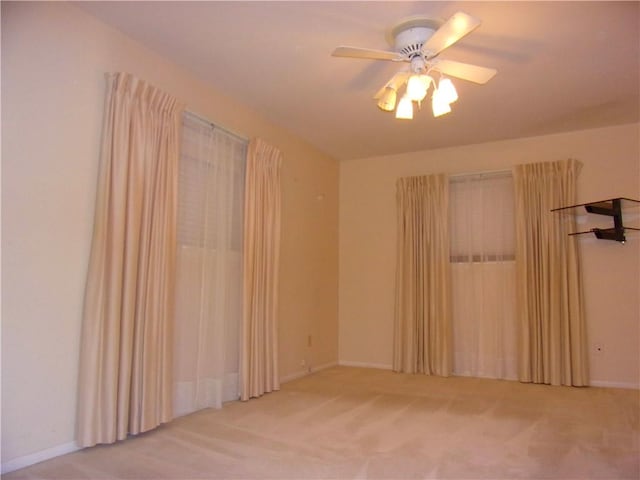 unfurnished room featuring baseboards, a ceiling fan, and carpet flooring