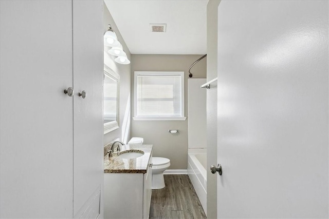 full bathroom featuring vanity, wood-type flooring,  shower combination, and toilet