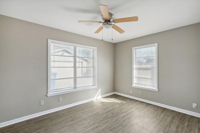 spare room with hardwood / wood-style flooring, a wealth of natural light, and ceiling fan