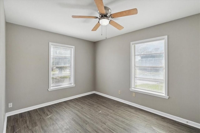 spare room with ceiling fan, dark hardwood / wood-style flooring, and a wealth of natural light