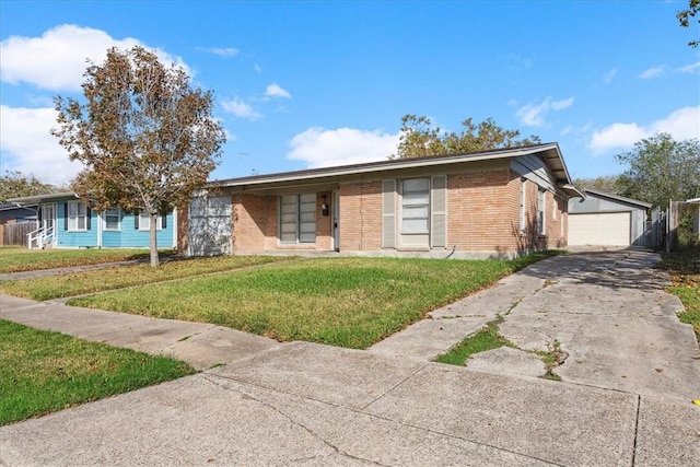 single story home featuring a garage, an outdoor structure, and a front lawn