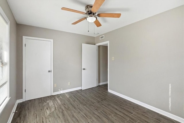 unfurnished bedroom featuring ceiling fan and dark wood-type flooring