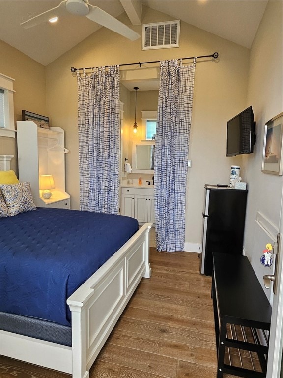 bedroom with ceiling fan, ensuite bathroom, wood-type flooring, and vaulted ceiling