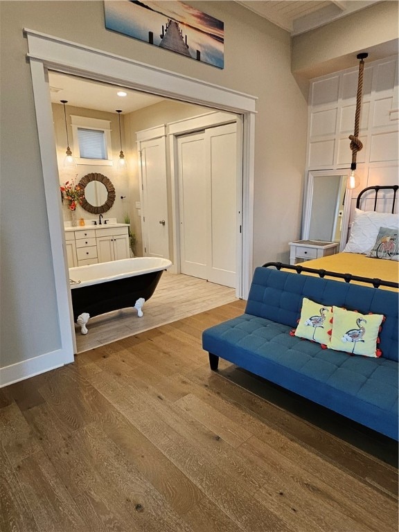 bedroom with hardwood / wood-style flooring and sink