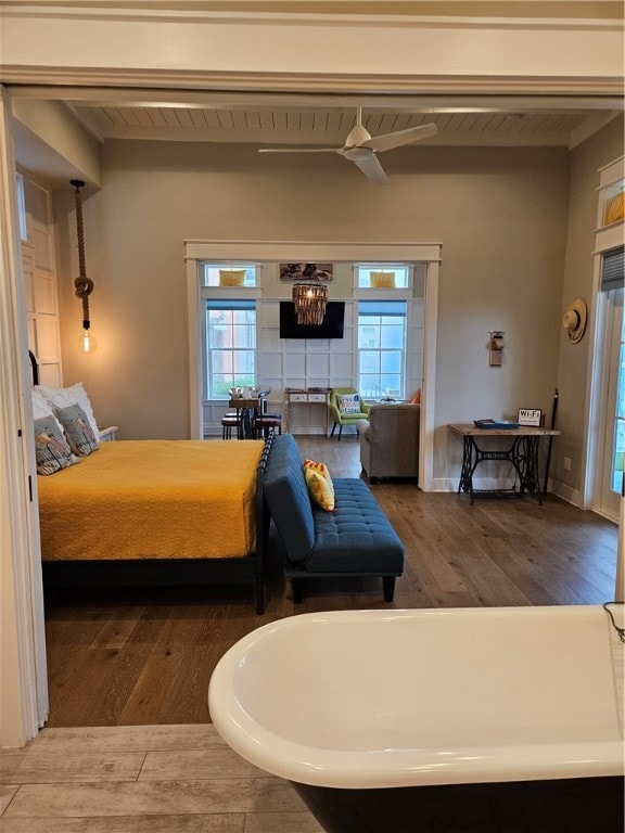 bedroom featuring hardwood / wood-style flooring, multiple windows, and a notable chandelier