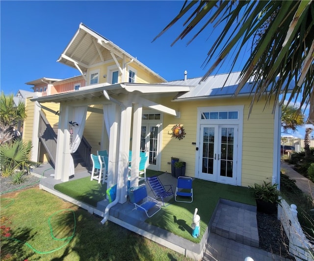 rear view of property with a lawn, french doors, and a patio