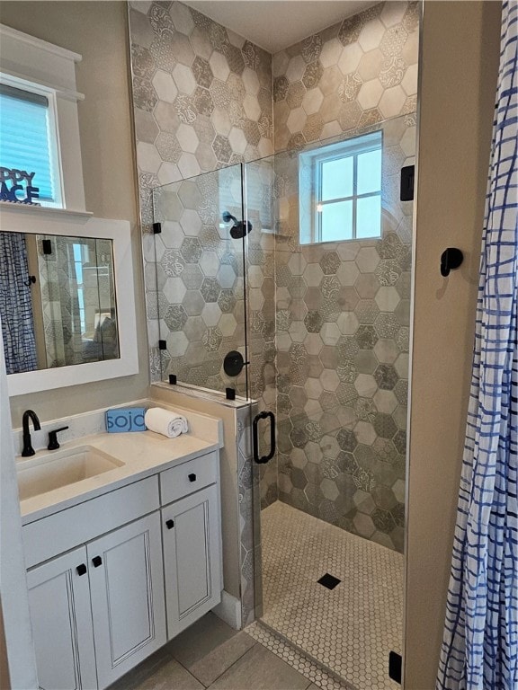 bathroom featuring tile patterned flooring, vanity, and walk in shower