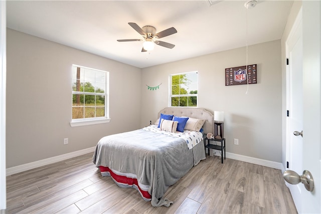 bedroom featuring light hardwood / wood-style floors, multiple windows, and ceiling fan