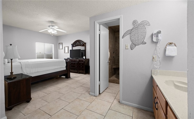 tiled bedroom with ceiling fan, sink, and a textured ceiling