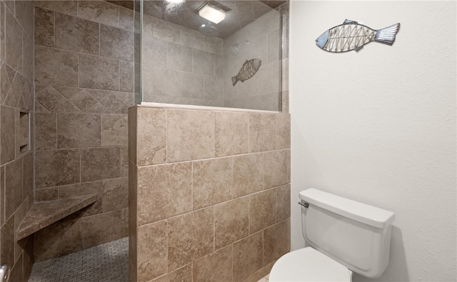 bathroom with toilet and tiled shower