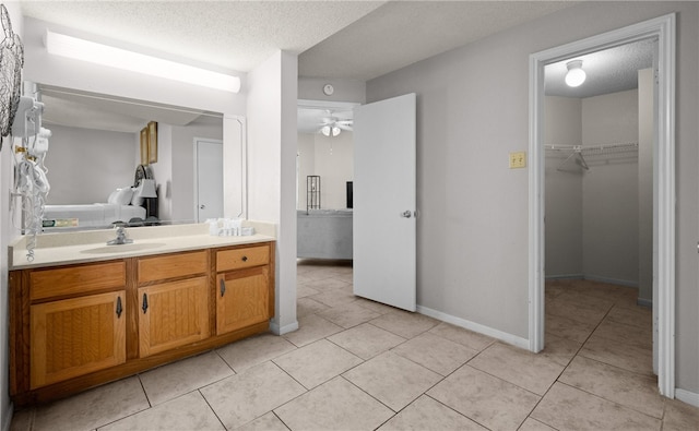 bathroom with tile patterned floors, ceiling fan, a textured ceiling, and vanity