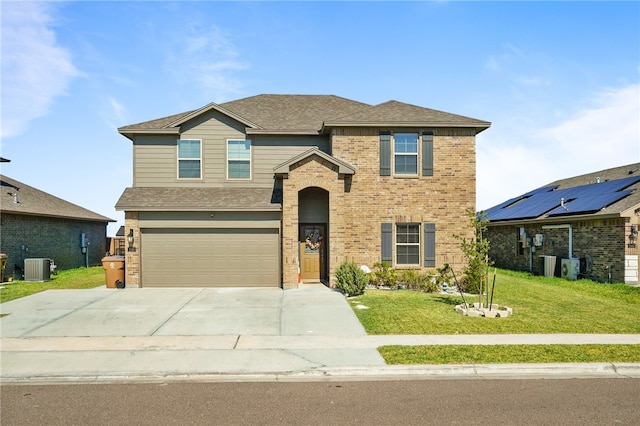 view of front of property featuring a front yard, a garage, and central air condition unit