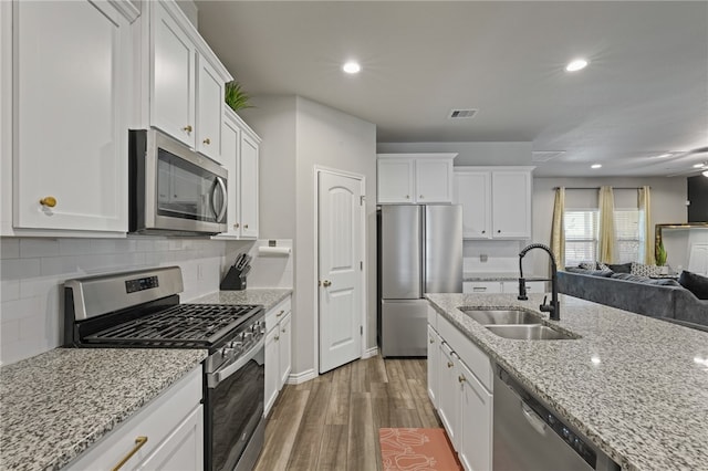 kitchen featuring stainless steel appliances, white cabinetry, dark hardwood / wood-style floors, and sink