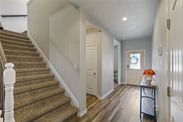 entrance foyer with dark wood-type flooring and a textured ceiling