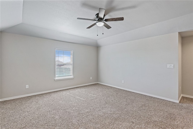 spare room featuring carpet, ceiling fan, and vaulted ceiling