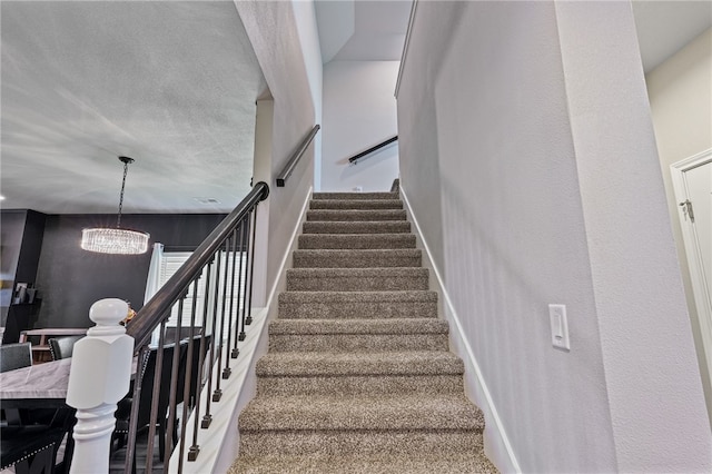 stairs featuring carpet floors and an inviting chandelier