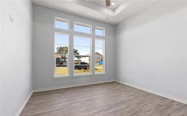 spare room featuring a wealth of natural light, light hardwood / wood-style floors, and ceiling fan