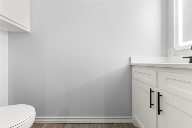 bathroom featuring hardwood / wood-style flooring, vanity, and toilet