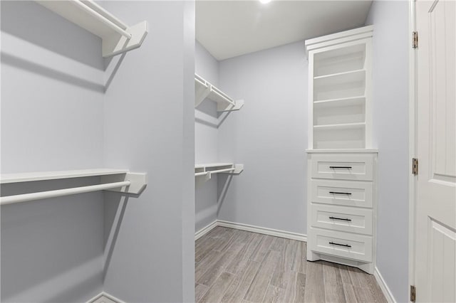 spacious closet with light hardwood / wood-style flooring